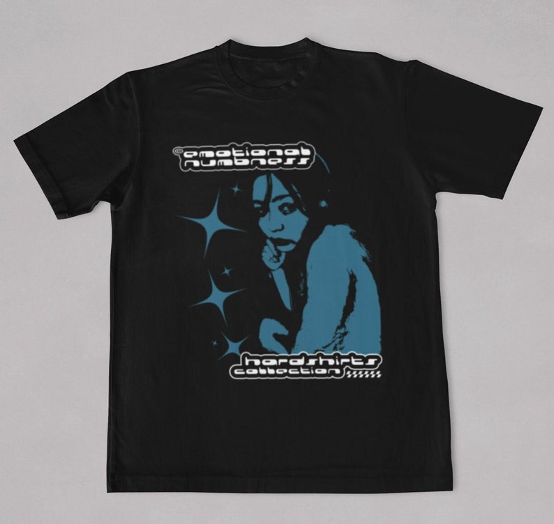May include: Black t-shirt featuring a blue graphic of a person and starbursts. The text "emotional numbness" is above the graphic, and "hardshirts collection" is below. A casual, unisex tee.