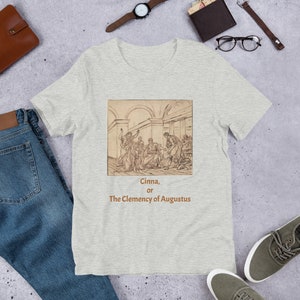 May include: A heather grey t-shirt featuring a black and white drawing of a historical scene. The text "Cinna, or The Clemency of Augustus" is printed below the drawing.