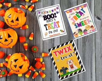 May include: Four printable Halloween treat cards with colorful text and illustrations. The cards feature the phrases "Boo! Here's a Treat for You!", "A Little Treat for Someone Sweet", and "Twix or Treat?" with images of bats, candy, and pumpkins.