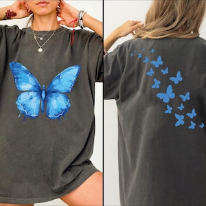 a woman wearing a blue butterfly t - shirt