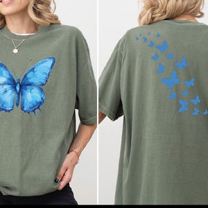 a woman wearing a green shirt with a blue butterfly on it