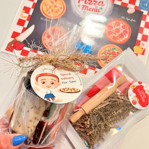 May include: A pizza-themed play set with a pizza menu, a small rolling pin, and play dough. The set includes a pizza menu with various pizza illustrations and a tag that says "Special Delivery For: Soni."