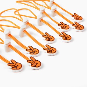 May include: A set of ten orange and white peace sign cord stoppers. The cord stoppers are made of a soft, flexible material and are perfect for adding a touch of fun to your cords.