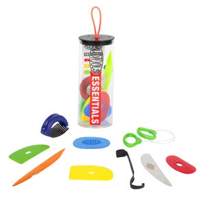 May include: A collection of colorful pottery tools, including various shaped cutters, loop tools, and a wire tool. The tools are in a clear plastic tube with the word "ESSENTIALS" in red. Additional tools are scattered around the tube.