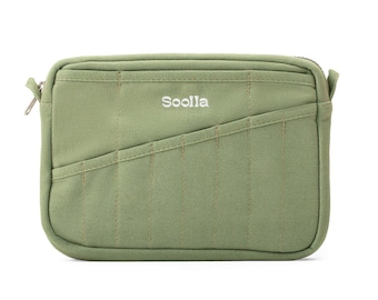 May include: A sage green rectangular pouch with a zipper closure. The pouch has a quilted design with vertical and diagonal stitching. The word "Sooila" is embroidered in white on the front of the pouch.