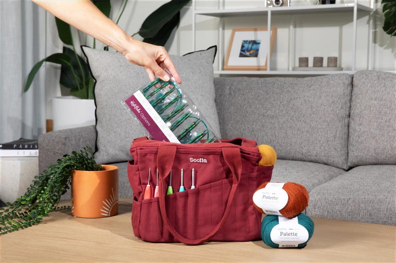 a person is putting items in a red tote bag