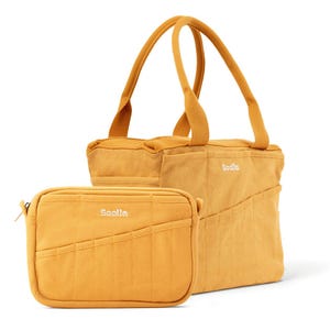 May include: Mustard-colored tote bag and matching zippered pouch. The tote bag has two handles and multiple pockets. The pouch has a zipper closure. Both items have the word "Soolla" embroidered on them.