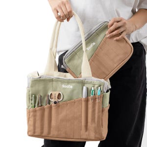 Close-up of the Deep Forest pouch showing the silver YKK zipper pull, dark green canvas loop, stitching, and zipper teeth.