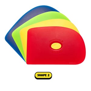 May include: A stack of colorful, flexible plastic tools in blue, green, yellow, and red. The red tool has the text "MUDTOOLS" and "SOOLLA" printed on it, with a yellow oval cutout. The text "SHAPE 2" is in a yellow box.