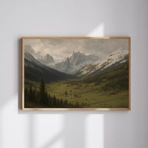May include: A framed landscape painting depicts a valley nestled between towering, snow-capped mountains. Lush green fields and a small village are visible in the valley, with dark green trees lining the slopes. The sky is overcast, and the painting is in a wooden frame.