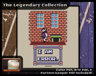 May include: Cross stitch pattern featuring a pixelated character from a video game standing in front of a brick wall with a window. The text "I AM ERROR." is displayed in a frame below the character.
