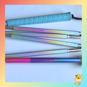 May include: A collapsible rod with a light blue textured grip and a black cord. The rod features a metallic iridescent finish that shifts between silver, blue, and purple tones. One segment displays pink text reading "fine the tweaker".