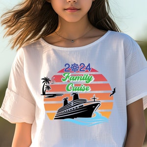 May include: White t-shirt featuring a graphic design of a cruise ship sailing into a sunset with palm trees and the text "2024 Family Cruise".