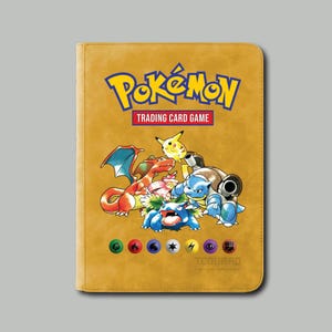 May include: Mustard-colored trading card binder featuring the Pok&eacute;mon logo and various Pok&eacute;mon characters. The binder has the text "Trading Card Game" and a row of colorful symbols at the bottom. The brand name "Tegaurd" is also visible.