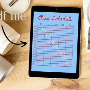 May include: A blue digital planner with a red "Class Schedule" title and a grid for scheduling classes. The planner is on a wooden surface with a white plate and a roll of paper.