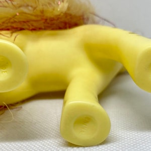 Puede incluir: Pony de juguete de pl&aacute;stico amarillo con una crin y cola rosa y dorada. El pony tiene una marca de copyright en la parte inferior de cada pie que dice "G1983 Hasbro Inc."