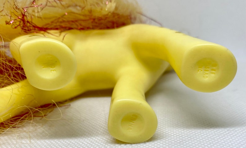 Puede incluir: Pony de juguete de pl&aacute;stico amarillo con una crin y cola rosa y dorada. El pony tiene una marca de copyright en la parte inferior de cada pie que dice "G1983 Hasbro Inc."