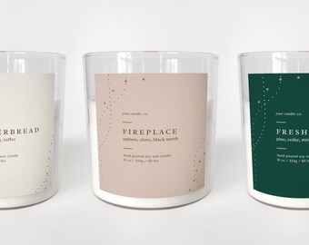 May include: Three glass candle jars with labels. The labels are beige, pink, and green with gold stars. The candle labels read "Gingerbread", "Fireplace", and "Fresh Wood".