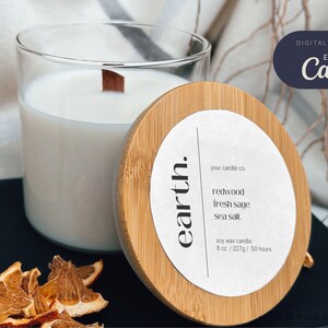 Zoom in on single candle and candle lid on kitchen counter. Candle as a white label written sideways. To the right is bold line and editable text of the candle company, scents, volume to the right 
 writtenof the candle name separated by bold line