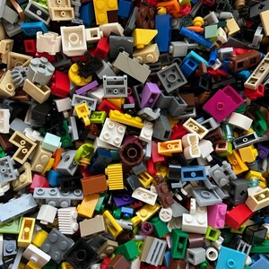 Peut inclure: Une grande collection de briques Lego color&eacute;es de diff&eacute;rentes formes et tailles. Les briques sont un m&eacute;lange de couleurs primaires, notamment le rouge, le bleu, le jaune, le vert et le noir.