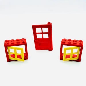 May include: Three red and yellow toy building blocks. Two blocks are open frames with yellow windows, and one is a red door with a window. The blocks are designed for children's construction play.