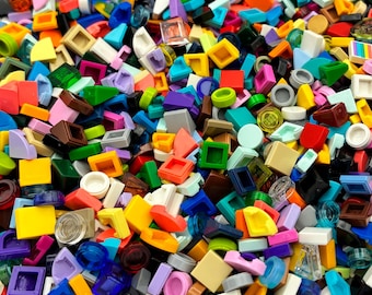 Peut inclure: Un assortiment vibrant de blocs de construction en plastique colorés de différentes formes et tailles. Les blocs sont dans des tons de rouge, jaune, vert, bleu, violet et blanc, créant un mélange visuellement stimulant. L'image présente une variété de petites pièces géométriques.
