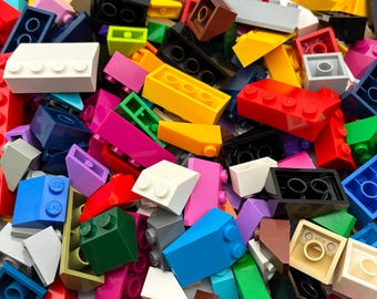 Peut inclure: Un assortiment vibrant de blocs de construction en plastique colorés de différentes formes et tailles. Les blocs sont dans des tons de rouge, jaune, bleu, vert, rose, blanc et noir. Certains blocs ont des tenons, d'autres ont des trous. Un jouet ludique et créatif.