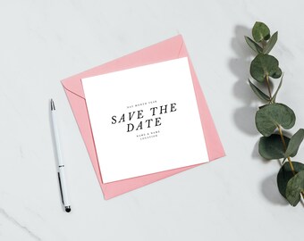 May include: A white card with the text "Save the Date" in black font, with the date, names, and location below. The card is in a pink envelope on a white marble surface with a sprig of eucalyptus.