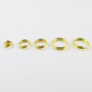 May include: Four gold jump rings of different sizes. The rings are made of metal and have a smooth finish.