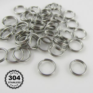 May include: A pile of silver-coloured metal key rings. The key rings are made of 304 stainless steel.