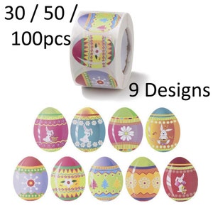 May include: A roll of 100 Easter egg stickers featuring 9 different designs. The stickers depict colourful eggs with various patterns and images, including bunnies, flowers, and snowflakes. The roll is labelled "30 / 50 / 100pcs" and "9 Designs".
