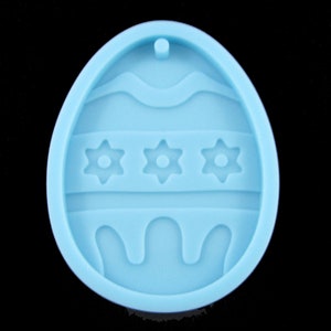 May include: Light blue silicone mould shaped like an Easter egg with a wavy design and three flower shapes.
