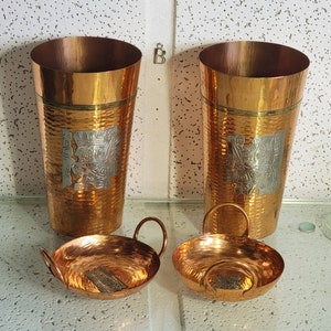 以下が含まれることがあります： 銀色のアクセントが付いたハンマード銅製のカップ2つと、銀色のアクセントが付いたハンマード銅製のボウル2つ