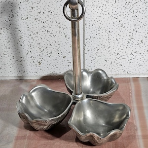 Peut inclure: Un plat de service en argent à trois sections avec une poignée centrale. Chaque section est en forme de coquille Saint-Jacques.