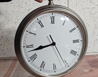 Large silver clock white brass, prestige clock, made in Taiwan, black roman numerals. Battery operated, ring for hanging, open with coin.