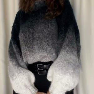 Può includere: Un maglione di maglia nero e bianco ombré con maniche lunghe e collo alto.