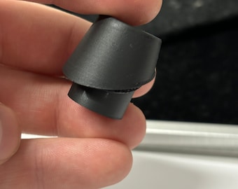 May include: A black rubber earplug with a cone shape. The earplug is designed to block out noise.