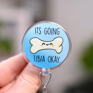 May include: A blue and white retractable badge holder with a cartoon bone and the text "ITS GOING TIBIA OKAY."