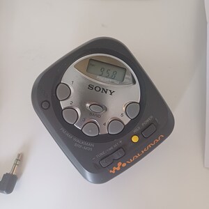 May include: A black Sony Walkman SRF-M35 AM/FM radio with a silver faceplate and a digital display showing 95.8. The radio has a number of buttons, including a power button, a tune/time set button, a hold button, and a band button. The radio also has a clock button and a preset button.