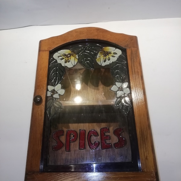 Vintage wall mounted spice rack with decorative glass fronted door, 8 standard jar capacity. 1980's