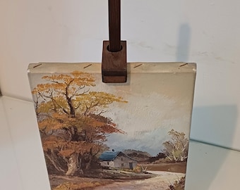 Vintage miniature wooden easel with small oil painting depicting a country scene