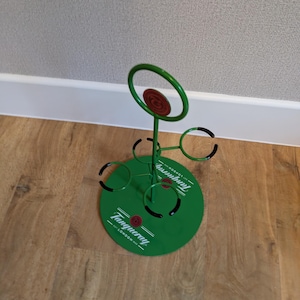 Pode incluir: Porta-copos de metal verde com an&eacute;is pretos e um logotipo Tanqueray. O porta-copos &eacute; projetado para segurar seis copos.