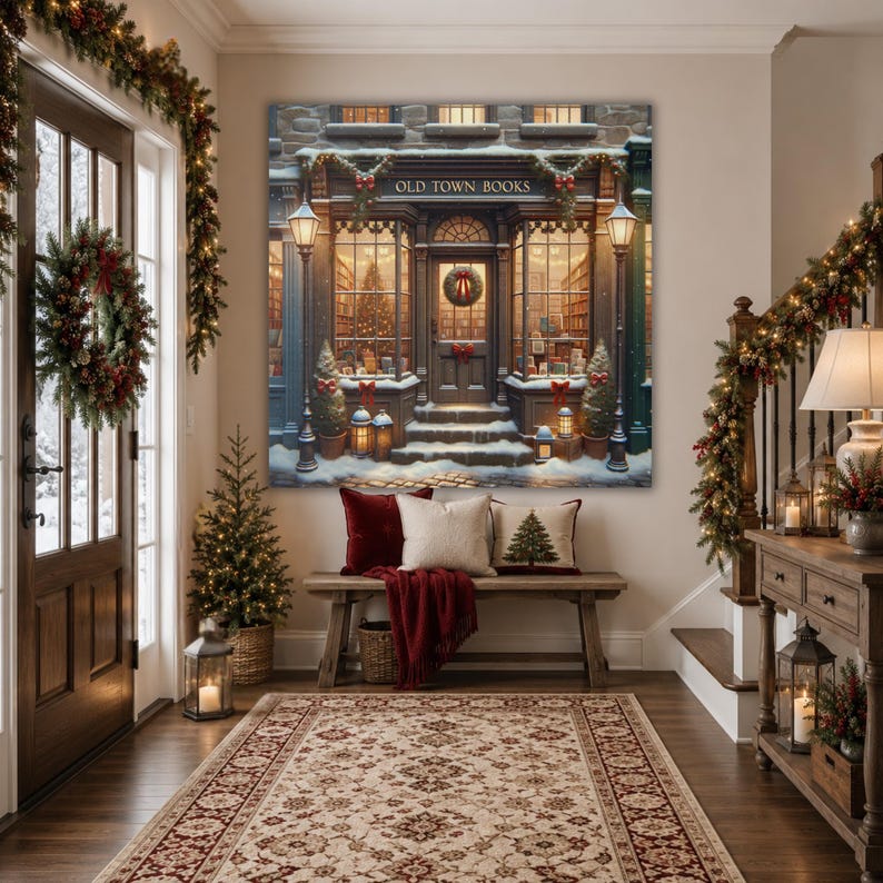 May include: A large square wall art print depicting a snowy storefront labeled OLD TOWN BOOKS, featuring warm interior lighting, holiday wreaths, and lanterns. Below, a wooden bench holds a red velvet pillow and a cream pillow with a tree graphic.