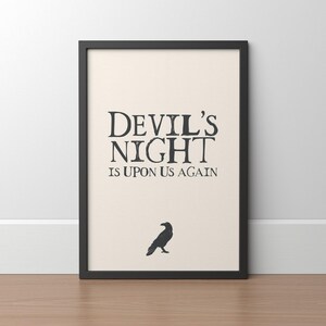 May include: Black framed print with a white background and black text that reads "Devil's Night is Upon Us Again". A black silhouette of a raven is below the text.