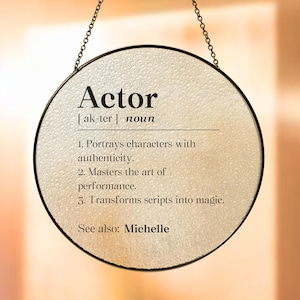 May include: A round, framed sign with a white background and black text. The sign reads "Actor [ak-ter] noun 1. Portrays characters with authenticity. 2. Masters the art of performance. 3. Transforms scripts into magic. See also: Michelle"