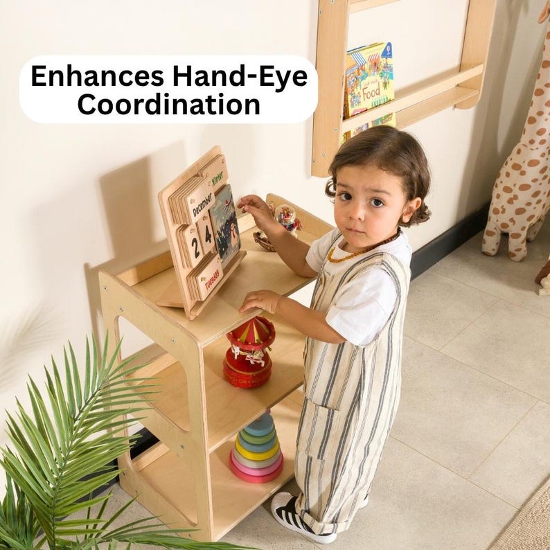 May include: A wooden activity table with a calendar, a red carousel, and a colorful stacking toy. The text "Enhances Hand-Eye Coordination" is displayed above the table. A child in a striped jumpsuit is interacting with the toys.