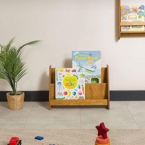 We combine Large Toddler Montessori Bookshelf and Mid Century style Modern Book Shelf Kids Room Montessori Furniture. Here is Wooden Low Nursery Bookcase, Baby Book Box! This large toddler shelf can be best gift from family to new baby boy or girl, toddler or kids. This toddler bookcase will be perfect matches with her or him toddler furniture. Unique design montessori bookcase will be perfect gift as a nursery book shelves and kids room bookcase.