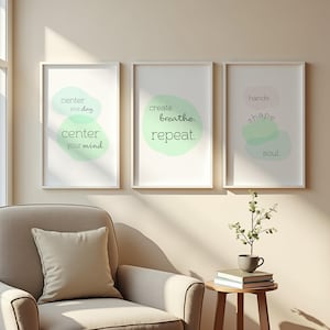 Könnte beinhalten: Drei gerahmte Kunstdrucke mit weißen Rahmen. Jeder Druck zeigt inspirierenden Text in einem minimalistischen Design mit weichen, aquarellartigen Formen in Grün und Rosa. Der Text enthält Sätze wie "center your day" und "create breathe repeat."