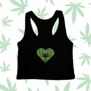 Könnte beinhalten: Schwarzes Racerback-Tanktop mit einem grünen Marihuana-Blatt in einem Herz.