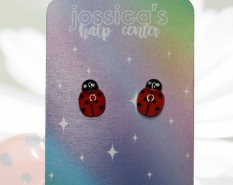 May include: A pair of ladybug stud earrings on a card with the text "jossica's half center" and "ig/tiktok: @jossicashalpcenter".
